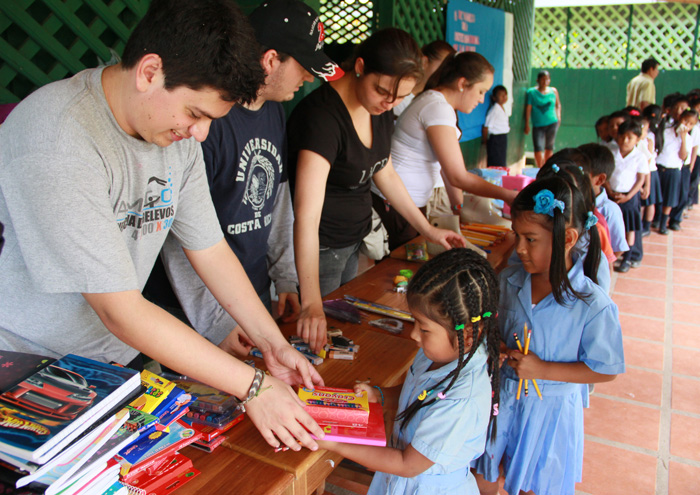Children receive the donation of school supplies from the hands of students from the University Community Service and workers at the Clodomiro Picado Institute (photo Anel Kenjekeeva).