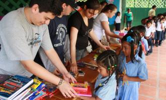 Children receive the donation of school supplies from the hands of students from the University Community Service and workers at the Clodomiro Picado Institute (photo Anel Kenjekeeva).